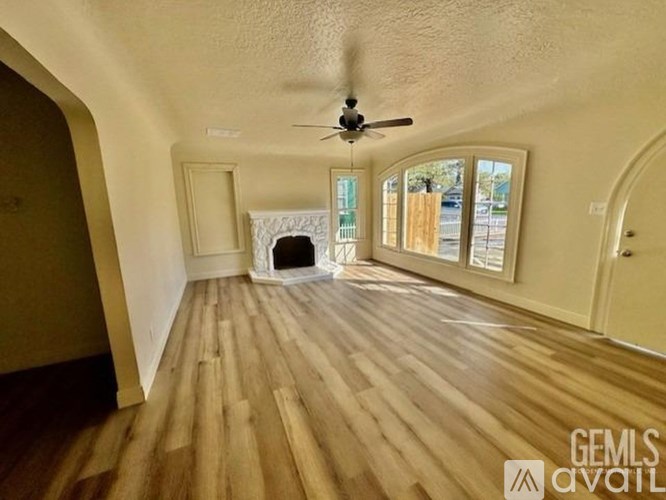 A room with wooden flooring and a ceiling fan.