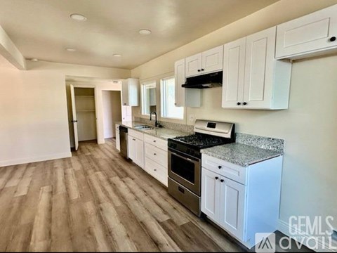 A kitchen with white cabinets and a granite countertop.