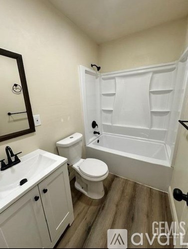 A white bathroom with a toilet, sink, and bathtub.