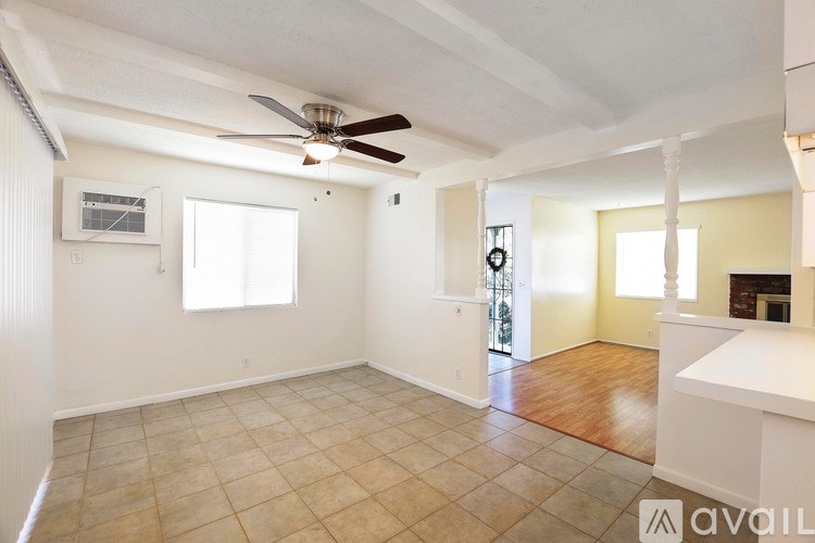 A spacious room with a ceiling fan and tiled flooring.