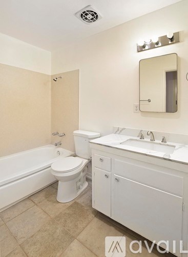 A bathroom with a toilet, sink, and bathtub.