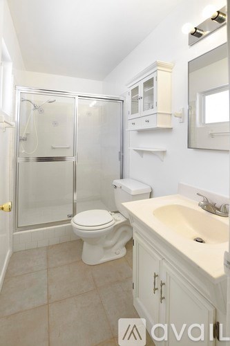 A bathroom with a toilet, sink, and shower.