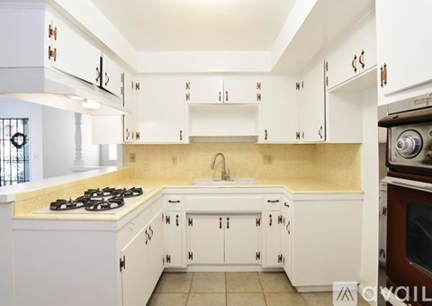 A kitchen with white cabinets and a yellow backsplash.