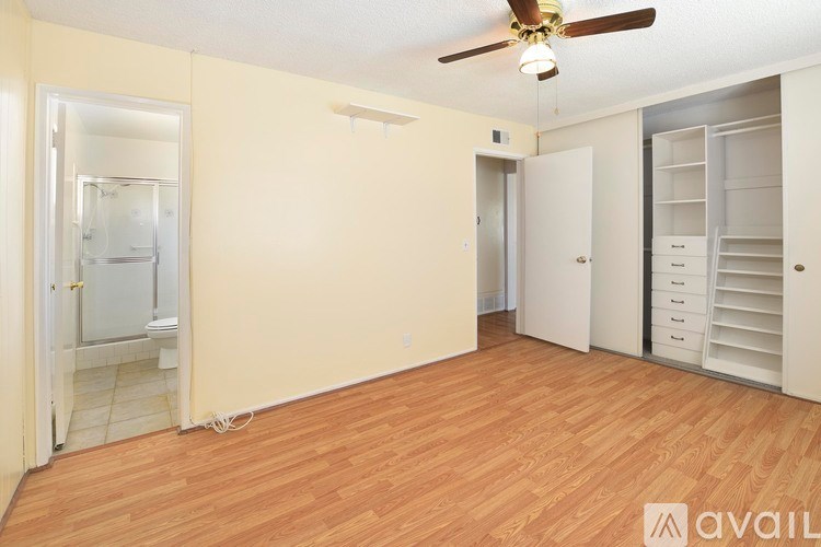 A room with a ceiling fan and wooden flooring.