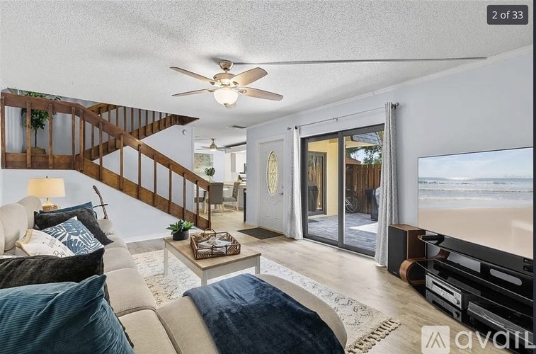 A living room with a couch, a coffee table, and a ceiling fan.