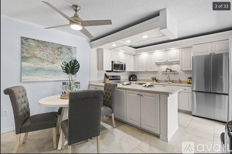 A kitchen with a table and chairs and a painting on the wall.