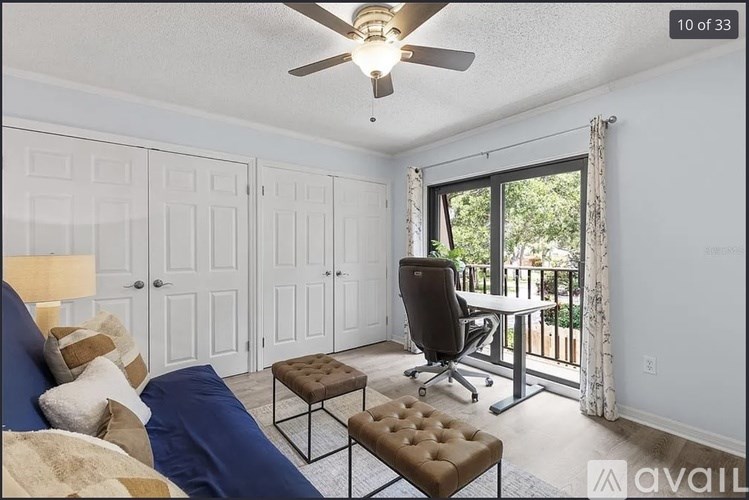 A bedroom with a bed, chair, and a window with a view of the backyard.