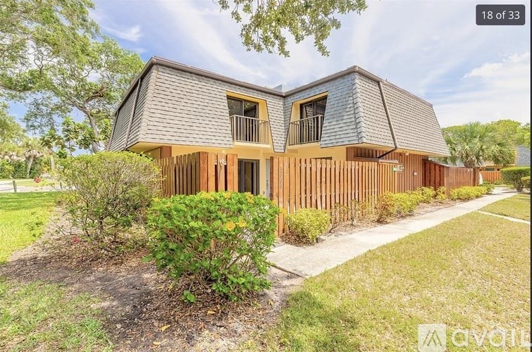 A modern house with a grey roof and wooden fence.