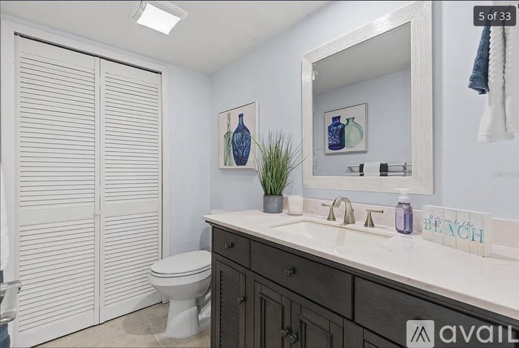 A bathroom with a toilet, sink, and a mirror.