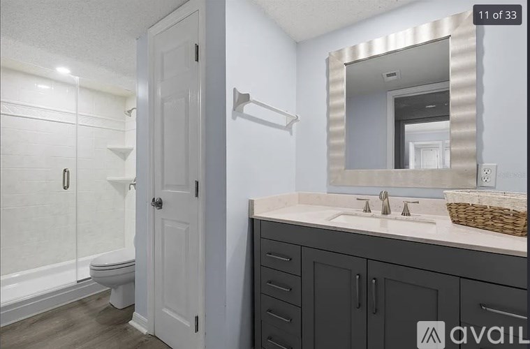 A bathroom with a white toilet, a sink, and a mirror.