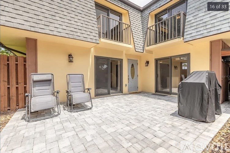 Two chairs are placed on a patio in front of a house.