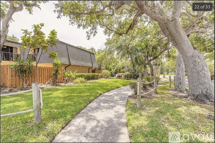 A pathway leads to a wooden building surrounded by greenery.