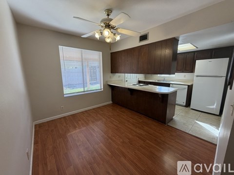 A kitchen with wooden floors and white appliances.