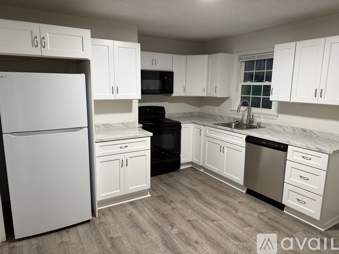 A kitchen with white cabinets and a black stove top oven.