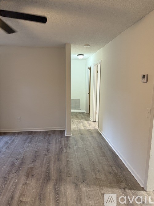 A room with a wooden floor and a ceiling fan.
