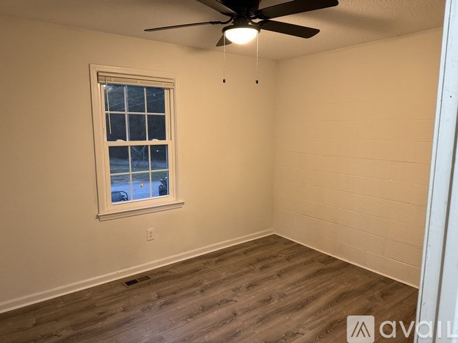 A room with a window and a ceiling fan.
