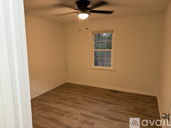 A room with a ceiling fan and a window.