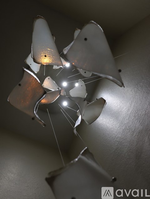 A broken light fixture with a hole in the center and sparks flying out.