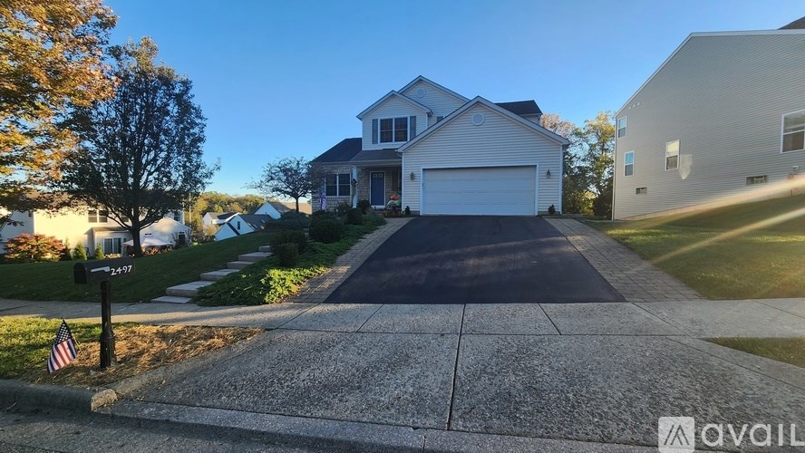 A house with a driveway and a mailbox is for sale.