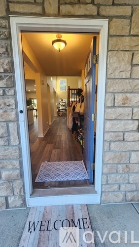 A welcome mat is on the door mat in front of a door.