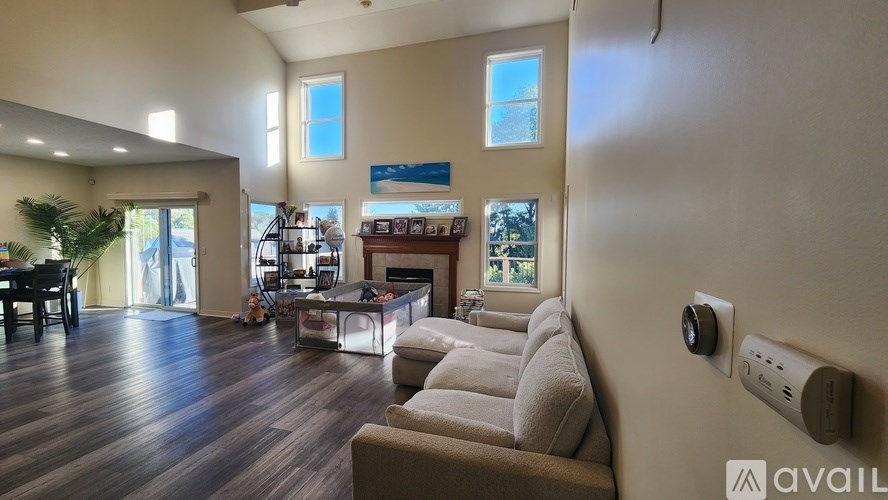 A living room with a couch, a table, and a wall-mounted air conditioner unit.