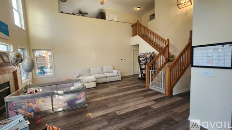 A living room with a white couch and a staircase.