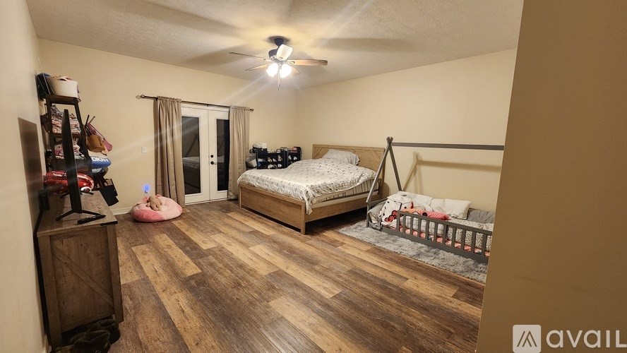 A bedroom with a bed, dresser, and window.