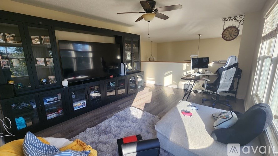 A living room with a large TV and a gaming chair.