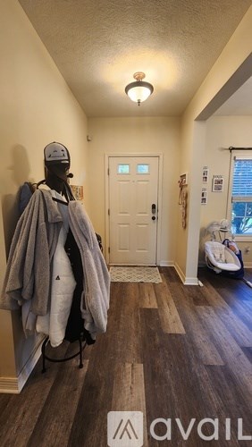 A hallway with a coat rack and a door.