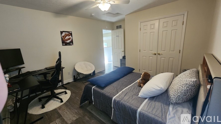 A bedroom with a bed, desk, and chair.