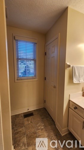 A bathroom with a window and a sink.