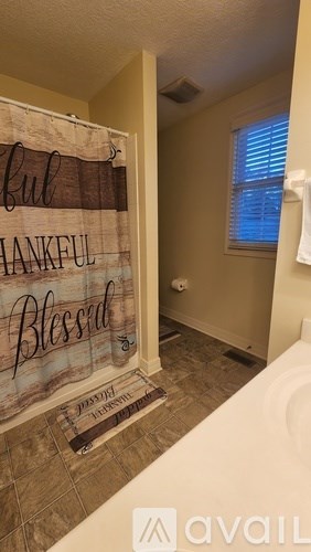 A bathroom with a wooden sign that says "Blessed" on the wall.