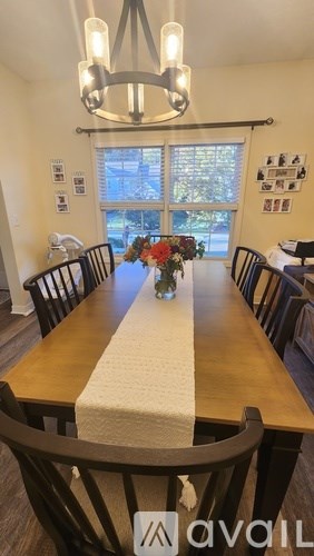 A dining room with a wooden table and chairs.