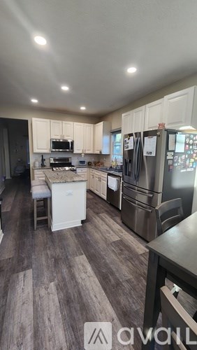 A kitchen with wooden floors and white cabinets.