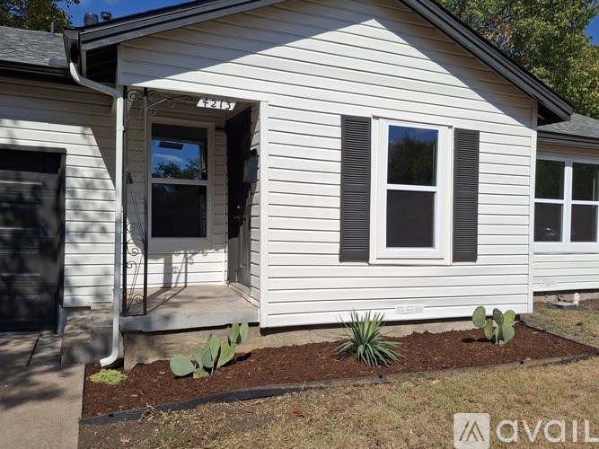 A small white house with a black door and windows.