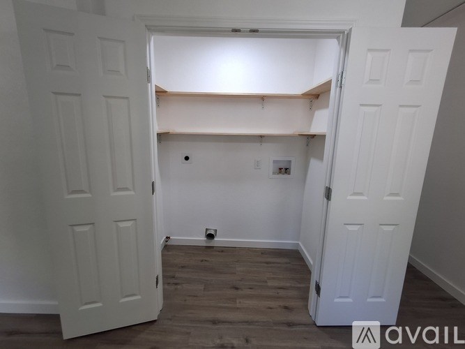 A room with white doors and wooden flooring.