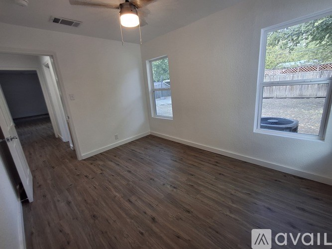 A room with wooden flooring and a ceiling fan.