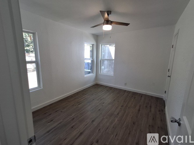 A room with wooden flooring and a ceiling fan.
