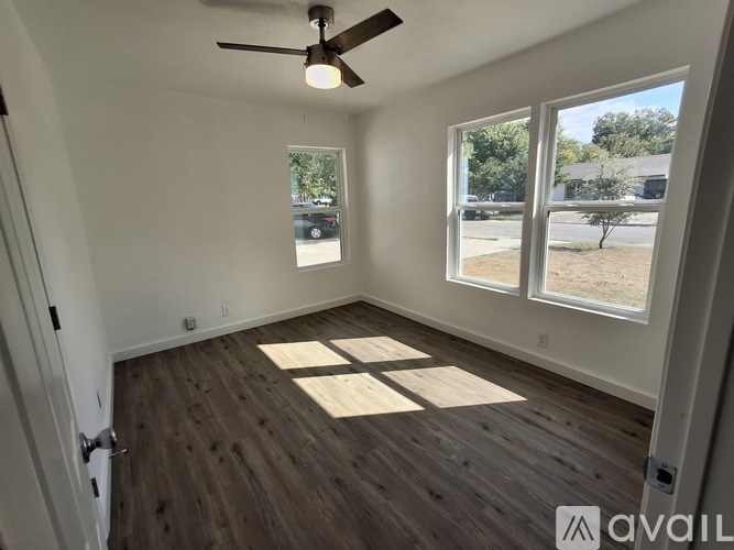 A room with a ceiling fan and wooden flooring.