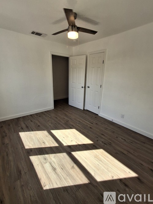 A room with wooden flooring and a ceiling fan.