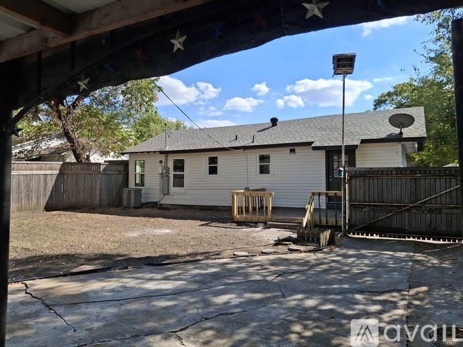 A white house with a black roof and a satellite dish on the roof.