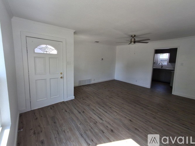 A room with a white door and a ceiling fan.