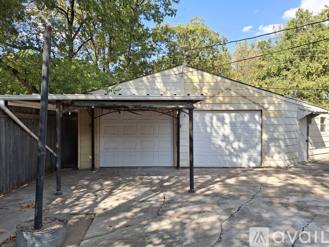 A detached garage with a white door and a metal roof.