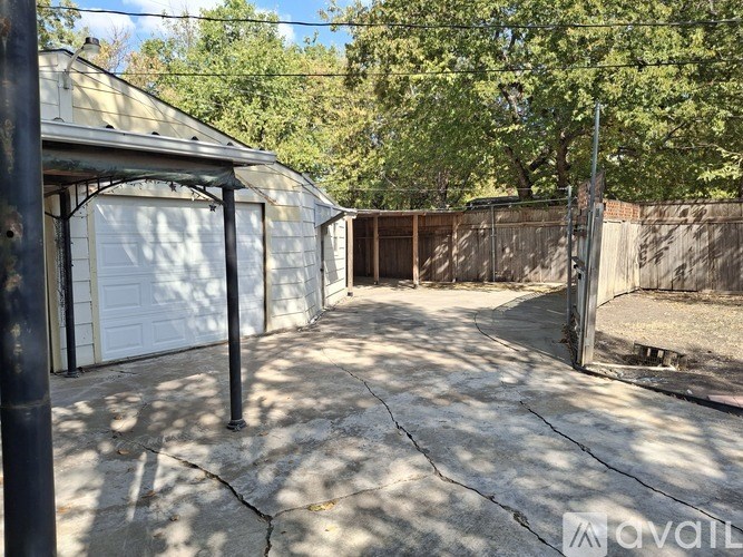 A backyard with a white garage door and a wooden fence.