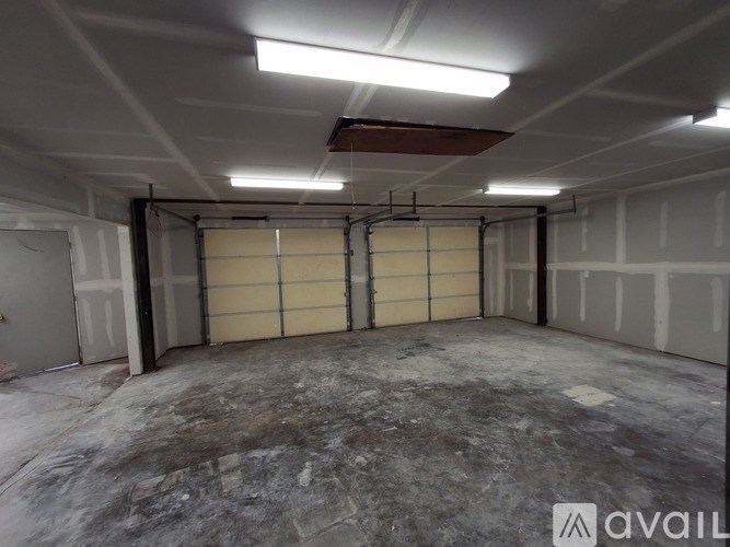 A large, empty garage with a concrete floor and walls.