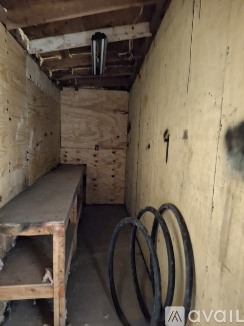 A room with wooden walls and a bench with a metal pipe on the floor.