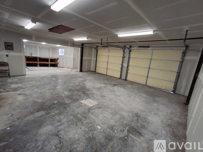 A large, empty garage with a concrete floor and walls.