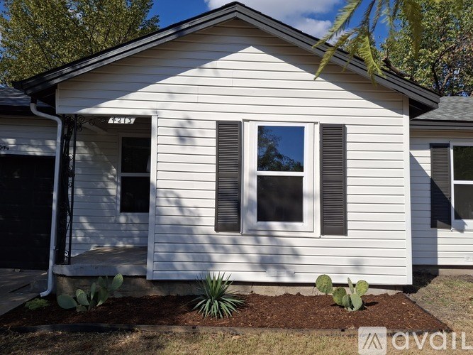 A white house with a black door and a window with a black frame.