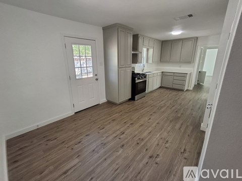 A kitchen with wooden floors and white walls.