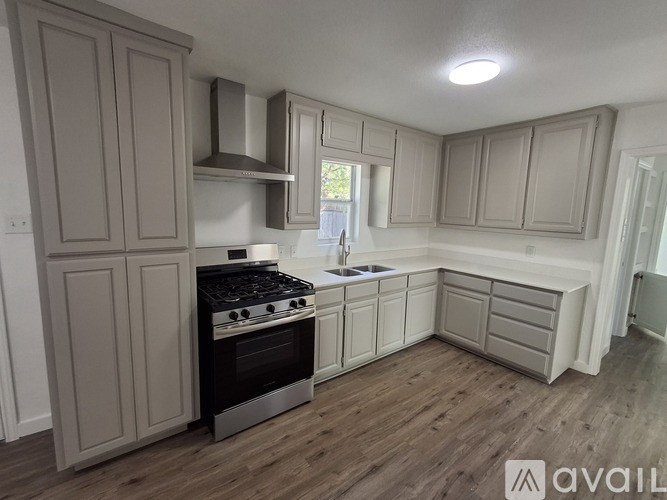 A kitchen with wooden floors and white walls.